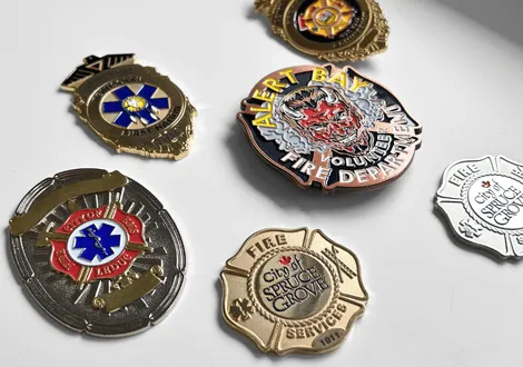 Collection of various fire and emergency service badges including Albert Bay Volunteer Fire Department and City of Spruce Grove Fire Services.