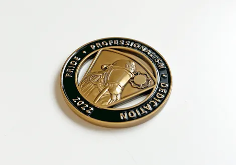 Round commemorative coin with a firefighter emblem and the words Pride, Professionalism, Dedication, 2022 on a white background.